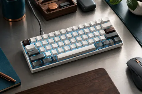 Clavier mécanique blanc Dierya DK61SE au format 60 %, éclairé en bleu glacier sur un bureau sobre.