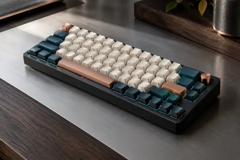Clavier mécanique compact noir à profil bas, posé sur un bureau en aluminium et bois sombre.