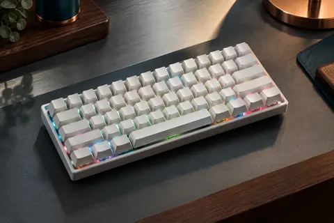 Clavier mécanique compact blanc de 63 touches avec rétroéclairage RGB sur un bureau sobre
